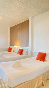 Ban Pak NamLaemsing Natural Beach Resort的配有红色枕头的客房内的2张白色床