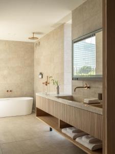 东京TRUNK(HOTEL) YOYOGI PARK的带浴缸的浴室和大窗户