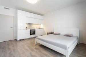 布拉格AuriApartments Libeň nový byt 1kk s garáží的一间白色卧室,配有床和厨房