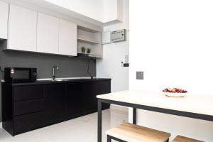 吉隆坡Stay @ NOVO Ampang的厨房配有黑白橱柜和柜台。