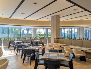 当格浪Fairfield by Marriott Jakarta Soekarno-Hatta Airport的餐厅设有桌椅和窗户。