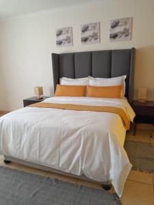 弗朗西斯敦Ambré Guesthouse的一间卧室配有一张带橙色枕头的大床