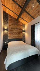 瓦特拉多尔内Tiny House Todireni的一间卧室设有一张带木制天花板的大床