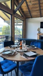瓦特拉多尔内Tiny House Todireni的一张带玻璃杯和餐巾的木桌和蓝色椅子