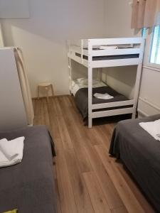 罗瓦涅米Hostel Tikka的客房设有两张双层床,铺有木地板。