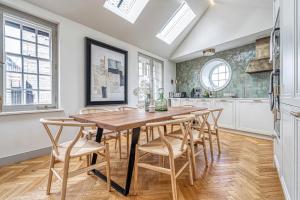 伦敦JOIVY Luxury flats near Big Ben and London Eye的厨房配有木桌和椅子