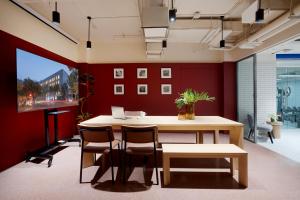 北京base佰舍服务式公寓（北京王府井隆福寺街店）的一间设有红色墙壁和桌椅的办公室