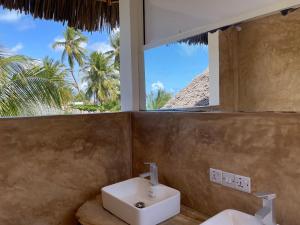江比阿Meliks的一间带水槽的浴室和一个带棕榈树的窗户。