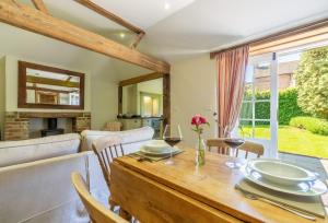 HenfieldHope Cottage - West Sussex的用餐室以及带桌椅的起居室。