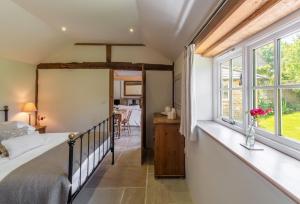 HenfieldHope Cottage - West Sussex的一间卧室设有一张床和一个窗口