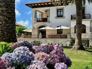 库迪列罗Hotel El Rosal de Cudillero的前面有鲜花的房子