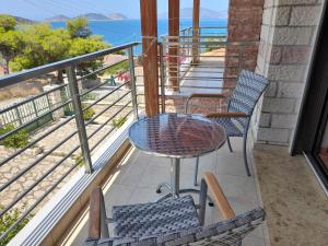 AlikíStone Villa at Alyki Beach的一个带桌椅的海景阳台