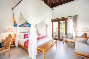 乌布Prabhu Ubud Villa的一间卧室配有天蓬床和沙发