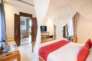 乌布Prabhu Ubud Villa的一间卧室配有一张带天蓬的白色床