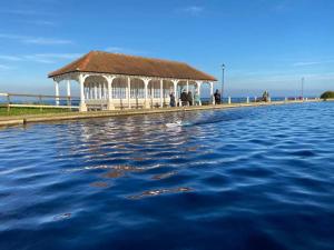 谢林汉姆Sheringham, Norfolk - Seaside Retreat - 15 min walk to beach的码头上的凉亭,前面有水