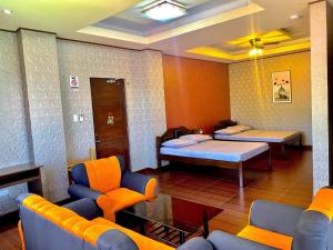 波尔多·格尼拉MinshukuKCS Hotel and Restaurant的一间医院间,配有两张床和一张沙发