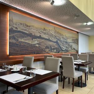 布拉格沓酒店的餐厅设有桌椅,墙上挂有绘画作品