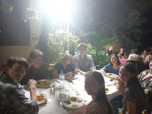 吉里特莱Green Garden Homestay的一群坐在桌子旁吃食物的人