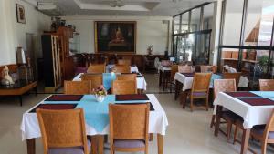 Kaeng Khloโรงแรมไทยงามพาเลซ (Thai Ngam Palace Hotel)的一间设有白色桌椅的用餐室