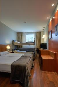 托雷利亚诺Hotel AG Express Elche的一间卧室配有两张床、一张桌子和一台电视。