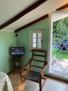 塞里纳Camera Singola con Terrazza Panoramica的一间带椅子、电视和窗户的房间