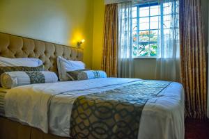 内罗毕Andes by 41 Haven的一间卧室设有一张大床和一个窗户。