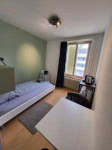 索洛图恩Casa Maria Apartments的一间卧室配有一张床、一张桌子和一个窗户。