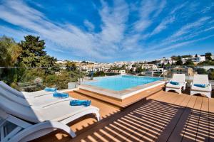 梅利哈Villa Goa - By Luxury Villas Malta的露台设有游泳池和甲板上的椅子
