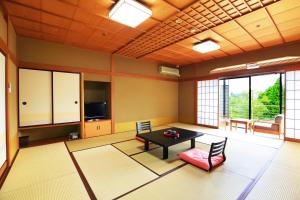 小松市Manten no Tsujinoya的客厅配有桌椅和电视。