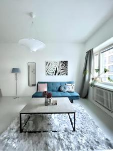 赫尔辛基Stylish Studio at the Heart of Helsinki的客厅配有蓝色的沙发和桌子