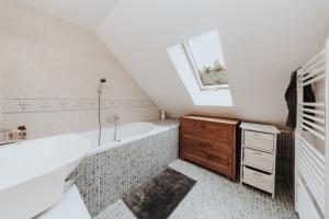 奥什恰德尼察Cabin Sonka的带浴缸、水槽和窗户的浴室