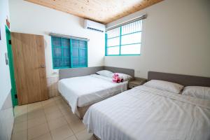 嘉义市家暖暖,老屋新生,房源內有戶外空間,嘉義市民宿013號的一间卧室设有两张床和窗户。