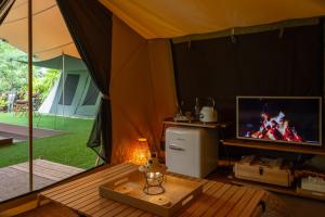清迈CAMP CAYLA - EDEN的一间带电视和桌子的帐篷间