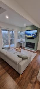 卢拉Treetop Leura Deluxe Family Cabin的客厅设有大沙发和电视