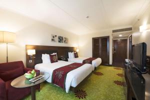 新德里萨凯特希尔顿花园酒店的酒店客房,设有两张床和一张沙发