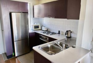 悉尼1 bedroom apartment in Paddington with beautiful view的厨房配有水槽和不锈钢冰箱