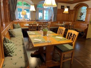 阿本斯贝格Hotel Jungbräu的一间带木桌和椅子的用餐室