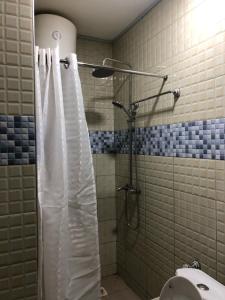 坎帕拉Royal Hotel Apartments的一间带白色淋浴帘的浴室