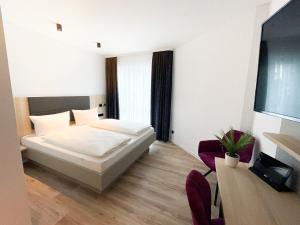 柏林HOLI City Apart Hotel Berlin的卧室配有一张床和一张桌子及椅子