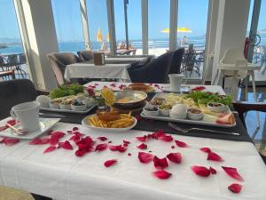 米拉斯Ni Marin Hotel的一张桌子,上面有几盘食物和玫瑰