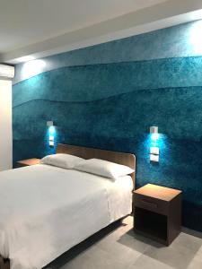 巴蒂帕利亚Eraora Hotel Village的卧室配有一张大床,墙上挂有绘画作品