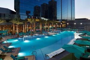 拉斯维加斯Hilton Grand Vacations Club Elara Center Strip Las Vegas的一个带椅子和遮阳伞的游泳池