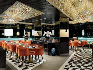 纽约纽约第一联合广场希尔顿千禧酒店的一间设有橙色桌椅的餐厅和一间酒吧