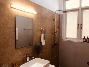 卡图纳耶克Ace Boutique Airport的浴室配有盥洗盆和带镜子的淋浴