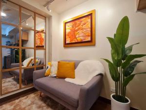 马尼拉Prisma Residences - Celeste的带沙发和植物的客厅
