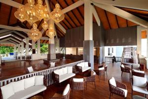卢穆特DoubleTree by Hilton Damai Laut的大堂设有白色的沙发、椅子和吊灯。