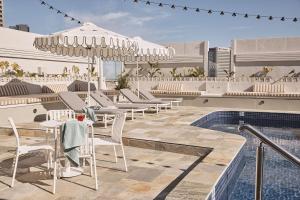墨尔本墨尔本雷吉斯中央商务区酒店的一个带桌椅的户外庭院和一个游泳池