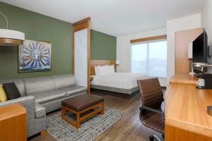 韦科Hyatt Place Waco - South的客厅配有沙发和1张床