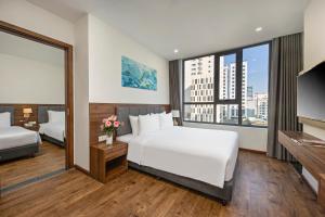 岘港Capecia Danang Hotel and Apartment的酒店客房设有两张床和大窗户。