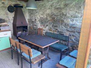 布兰纳Pension Pošta的厨房配有一张桌子和椅子,厨房设有石墙